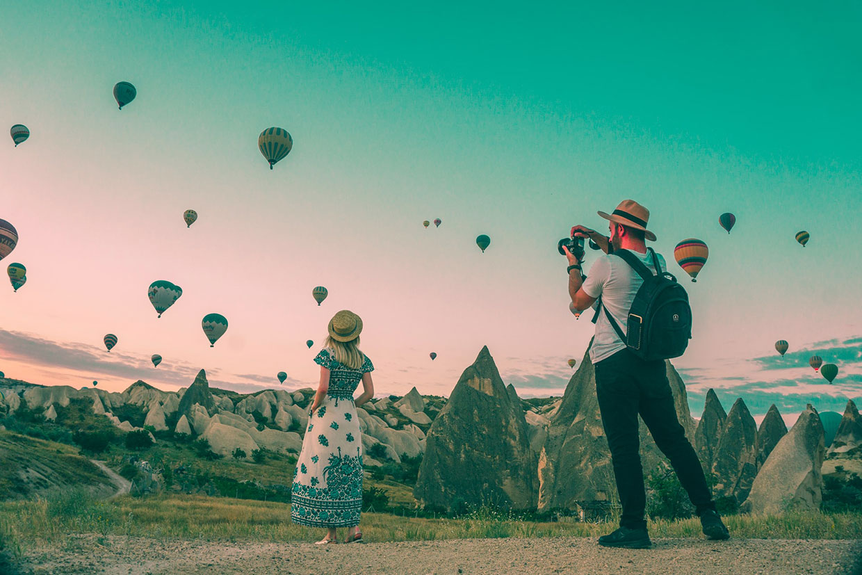 Man taking photo of hot air balloons